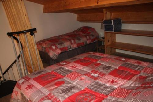 ein Schlafzimmer mit einer roten und weißen Decke auf einem Bett in der Unterkunft Le Cytise in Caille