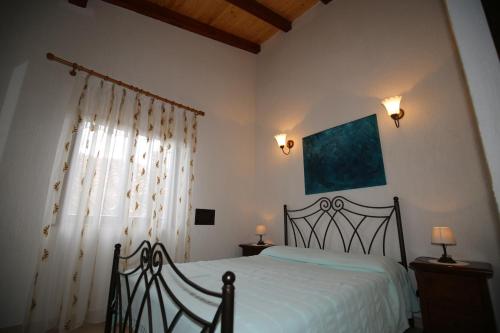 a bedroom with a bed with white sheets and a window at Apartment La roza in Funtana