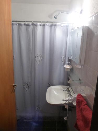 y baño con cortina de ducha y lavamanos. en Como en Casa en Rosario