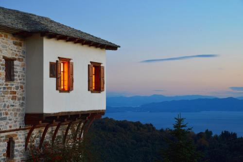 a house with orange windows with a view of a lake at Sakali Mansion in Pinakátai