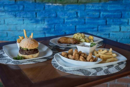 three plates of food on a table with a hamburger and french fries at Ribalta Hotel Barra da Tijuca by Atlantica in Rio de Janeiro