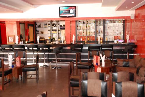 a bar in a restaurant with chairs and tables at New Farah Hotel in Agadir