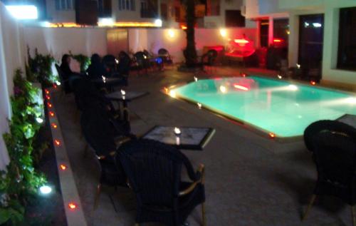 a swimming pool in a building with chairs and a table at New Farah Hotel in Agadir