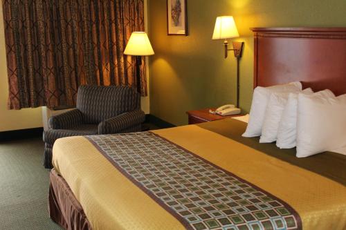 a hotel room with a bed and a chair at America's Best Value Inn Conyers in Conyers