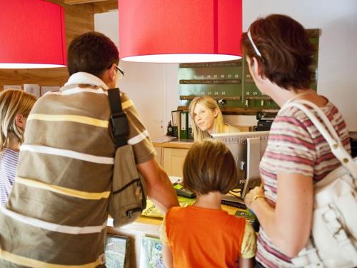 un grupo de personas de pie en una cocina preparando comida en Huttopia Beaulieu sur Dordogne, en Beaulieu-sur-Dordogne