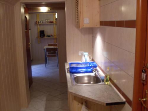 a small kitchen with a sink and a hallway at Apartament na Wrzosach in Toruń