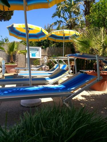 a group of blue lounge chairs and umbrellas at Hotel Casa Nicola in Ischia