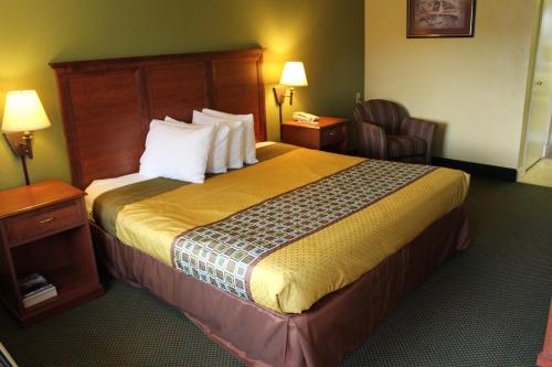 a hotel room with a large bed and a chair at America's Best Value Inn Conyers in Conyers