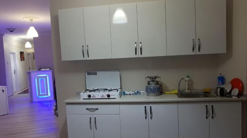 a kitchen with white cabinets and a counter top at Hakbilir Pansiyon in Amasra