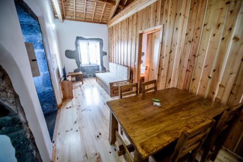 a wooden room with a table and a couch at Casa Branca da Chaminé in Cinco Ribeiras
