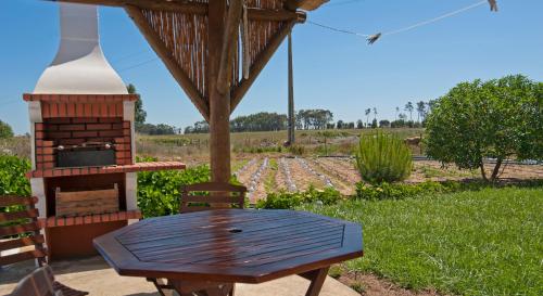 a picnic table and a grill in a field at Monte do Zeca in Zambujeira do Mar