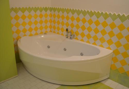 a bath tub in a bathroom with a tiled wall at Melalidone in Orosei