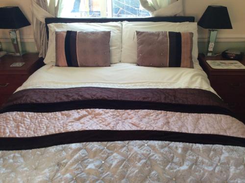 a bedroom with a bed with pillows on it at Alma Lodge Guest House in Plymouth