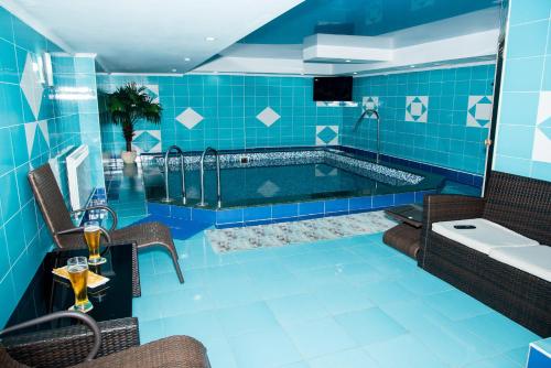 エッセントゥキにあるEspero Hotel Resort & Spaの青いタイル張りのバスルーム(バスタブ、シンク付)