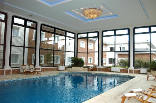 a swimming pool in a building with windows at Lagos Del Calafate in El Calafate