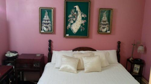 a bedroom with a white bed with two pictures on the wall at The Mays Place Bed and Breakfast in Elgin