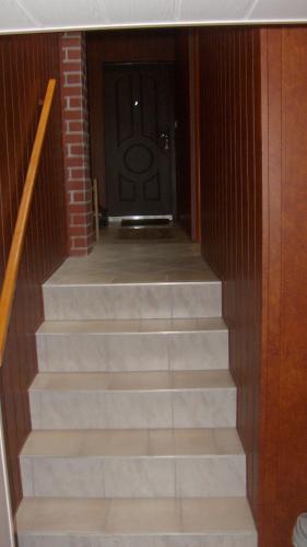 a set of stairs leading to a black door at Apartament na Wrzosach in Toruń