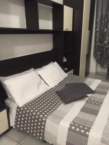 a bed with a black and white blanket and pillows at Casa Olbia in Olbia