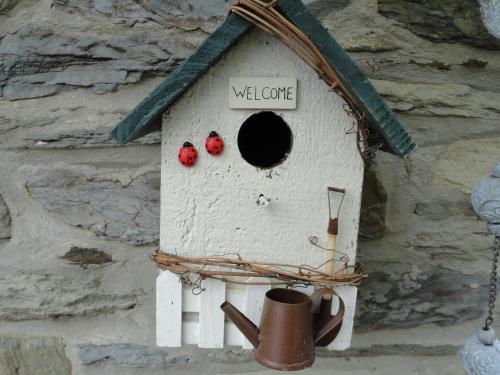 a bird house with three red berries in it at Le Héron in Houffalize