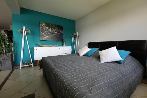 1 dormitorio con cama y pared azul en RheinDesign River Promenade, en Linz am Rhein