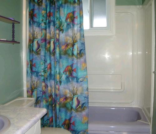 a bathroom with a shower curtain and a tub at Birch Haven by the Beach in Wasaga Beach