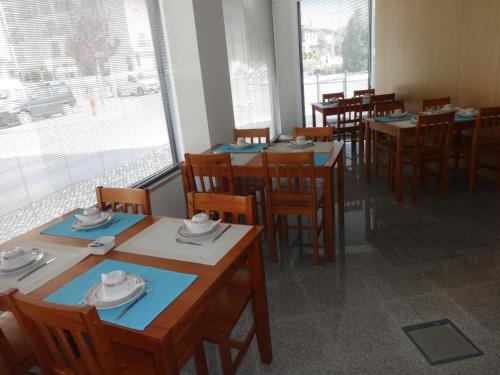 a dining room with tables and chairs and a window at Hotel Bonjardim in Tomar