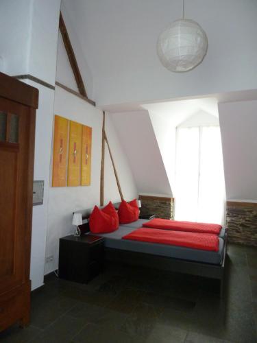 a bedroom with a bed with red pillows and a window at Winzerhaus Andel in Bernkastel-Kues