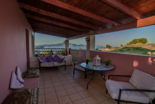 a balcony with a table and chairs and a view at Athenea Villas, Private Pools & Gardens in Keri