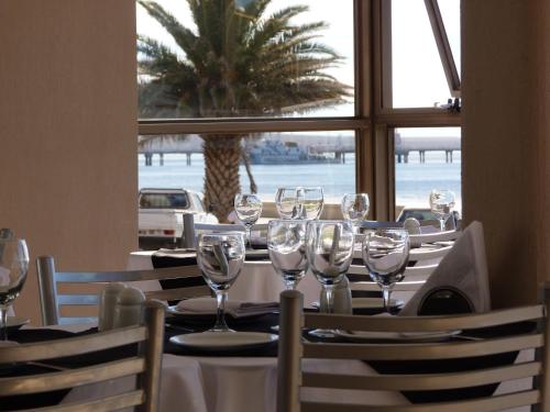a table with wine glasses on it in a restaurant at Costanera Hotel in Puerto Madryn