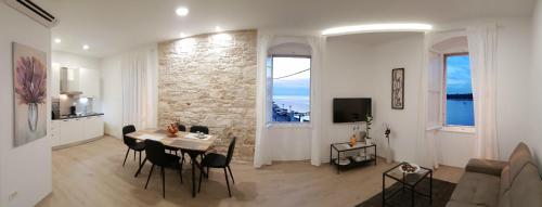 a white living room with a table and chairs at City Center Premium Apartment in Poreč