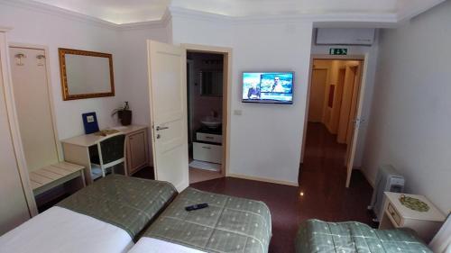 
a hotel room with a television and a bed at Guest House Šterk in Nova Gorica
