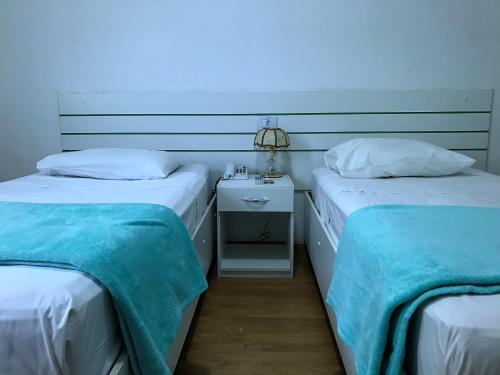 two beds sitting next to each other in a room at Hotel Family São Paulo - No Shopping FAMILY - No Brás in Sao Paulo