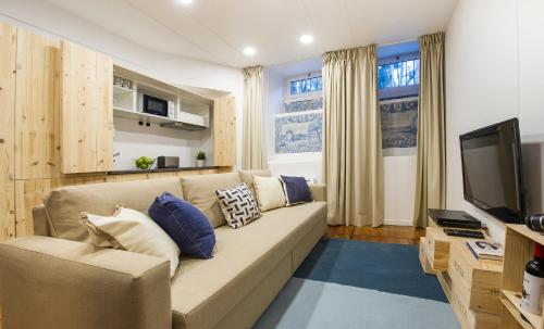 a living room with a couch and a television at Lisbon Dreams Estrela Suites in Lisbon