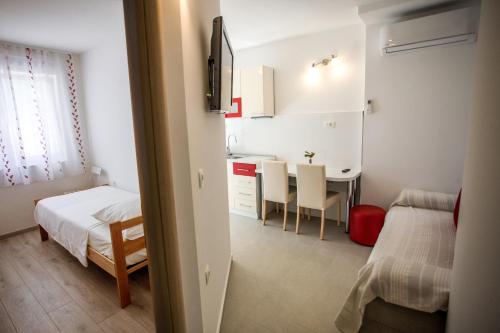 a small room with a bed and a desk and a kitchen at Apartments Lovor in Split