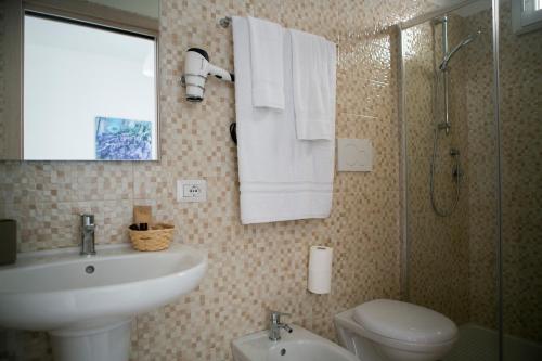 a bathroom with a sink and a toilet and a shower at B&B ARCADIA in Conversano