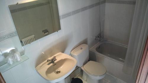 a bathroom with a sink and a toilet and a tub at Centro San Viator in Valladolid