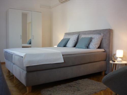 a bedroom with a large bed with blue pillows at Apartment Vesna in Supetar