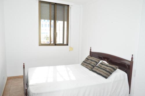 エル・プエルト・デ・サンタマリアにあるLa Goletaの窓付きの白い部屋のベッド1台