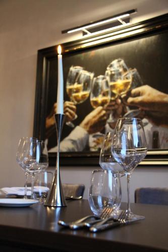 a table with wine glasses and a candle on it at Belgrave Sands Hotel & Spa in Torquay