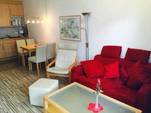 ドルム・ノイフェルトにあるHaus Amrum, Wohnung 17のリビングルーム(赤いソファ、テーブル付)
