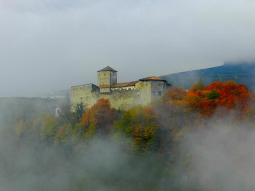 a castle on top of a hill in the fog at Al Trifoglio in Campodenno