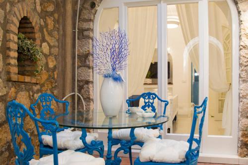 a blue table with chairs and a vase on it at Capri Blue in Capri