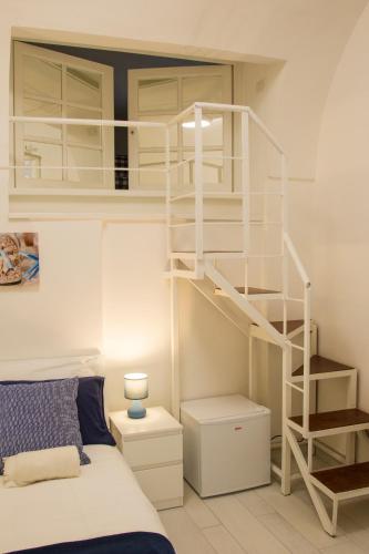 a bedroom with a white bunk bed and a spiral staircase at Capri Blue in Capri