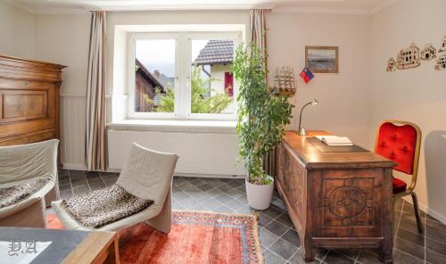 een woonkamer met een bureau en een raam bij 2,5 Zimmer Ferienwohnung mit Küche/Bad in Triesen