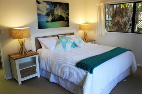 una camera con un letto, due lampade e una finestra di Close to beach ad Auckland