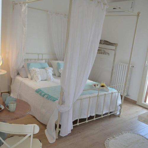 a bedroom with a white bed with a canopy at Vento d'aMare in Leporano