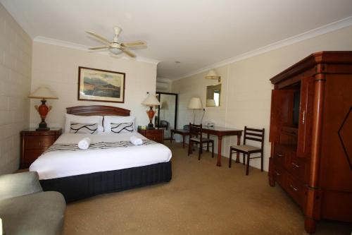 a hotel room with a bed and a table and chairs at Picton Valley Motel Australia in Picton