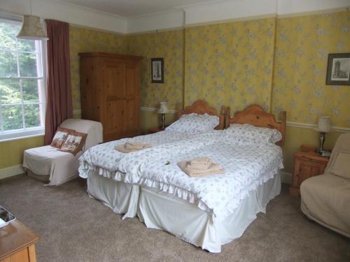 a bedroom with a large bed and a chair at Grange Farm House in Felixstowe