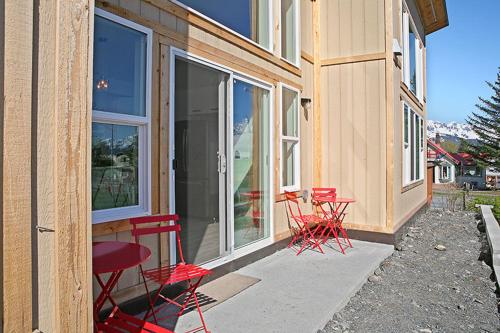 a group of red chairs sitting outside of a building at The Vue B&B in Seward