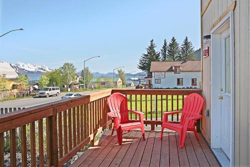 two red chairs sitting on a porch with a street at The Vue B&B in Seward